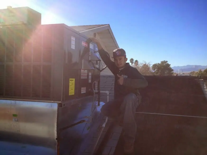 HVAC technician performing Boiler Repair on a rooftop unit in Luling